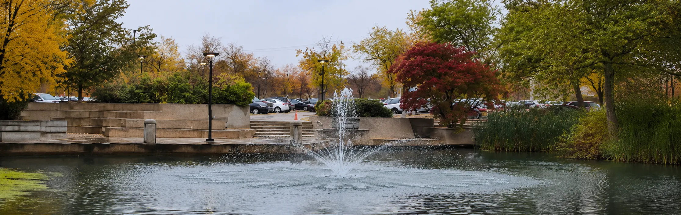 Floating pond fountain aerator improving water circulation and oxygen levels in a natural landscaped pond.
